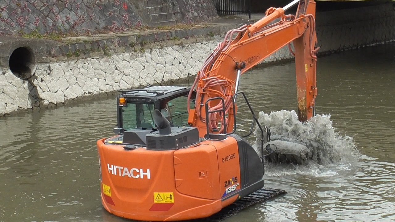 油圧ショベル（ユンボ）ZX135（日立建機）が川の土砂を豪快に掘り、橋