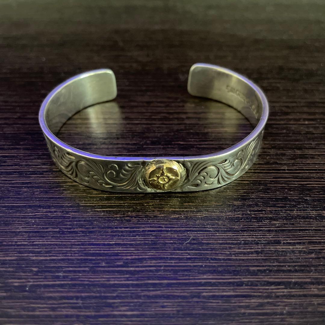 ファーストアロー K18付 平打12mmカラ草彫りバングル - メルカリ